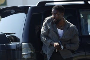O ator Yahya Abdul-Mateen II com expressão determinada em uma cena de ação da série Man On Fire.