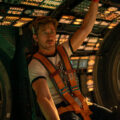 Ryan Gosling como o astronauta Ryland Grace dentro de uma nave espacial tecnológica com iluminação dramática.
