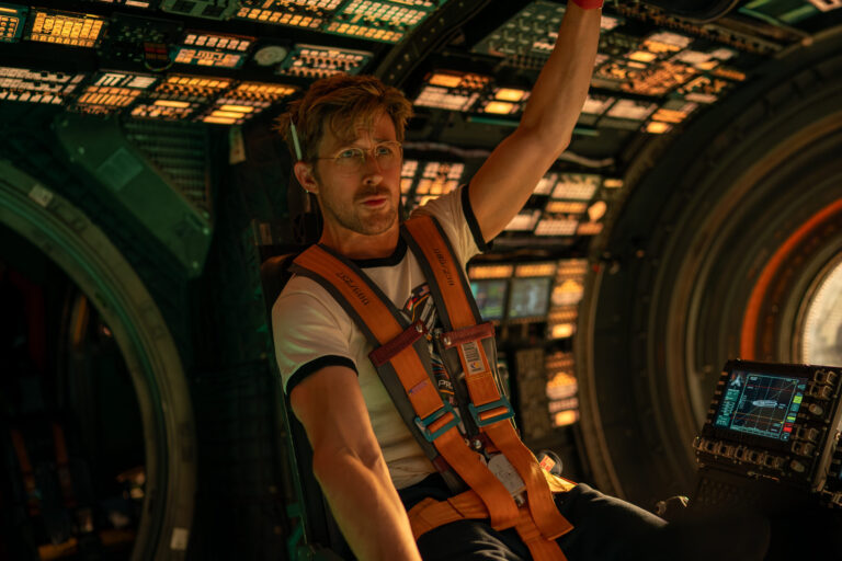 Ryan Gosling como o astronauta Ryland Grace dentro de uma nave espacial tecnológica com iluminação dramática.