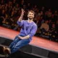 Daniel Radcliffe interagindo com a plateia no palco do Hudson Theatre na Broadway.
