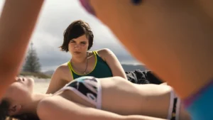 Cena do filme Big Girls Don't Cry com a protagonista Sid em uma praia da Nova Zelândia.