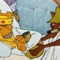 Cena de animação clássica da Disney onde Robin Hood, a raposa vestida de verde, usa uma linha de pesca para pescar o anel do Príncipe João (o leão covarde com coroa e aspecto de tigre), que dorme pesadamente em um trono cheio de moedas de ouro.