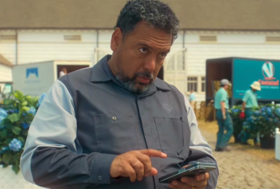 O ator Felix Solis caracterizado como seu personagem em uma cena de série, segurando um smartphone.