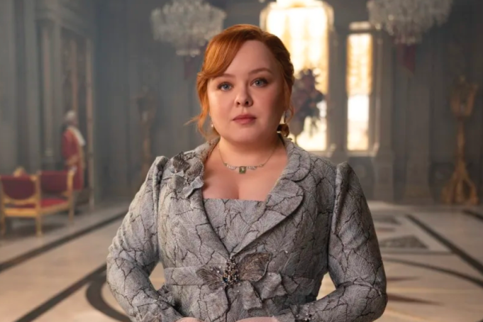 Atriz Nicola Coughlan posa para foto em evento de gala com fundo desfocado.