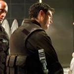 Uma cena do filme Doom (2005) mostrando Rosamund Pike e Dwayne Johnson em um ambiente escuro e futurista.