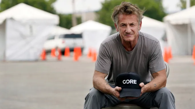 O ator Sean Penn e o presidente Volodymyr Zelensky sentados em um escritório na Ucrânia.