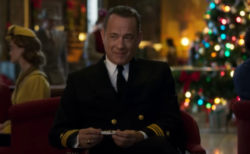 Homem ao fundo parcialmente oculto atrás de folha de papel quadriculado em primeiro plano