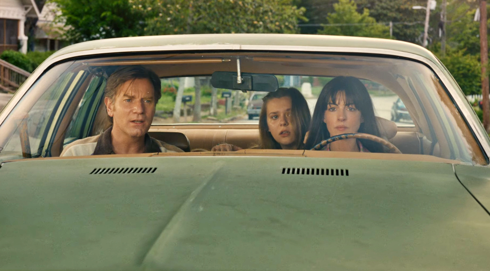 Anne Hathaway e Ewan McGregor dentro do carro em cena de The End of Oak Street