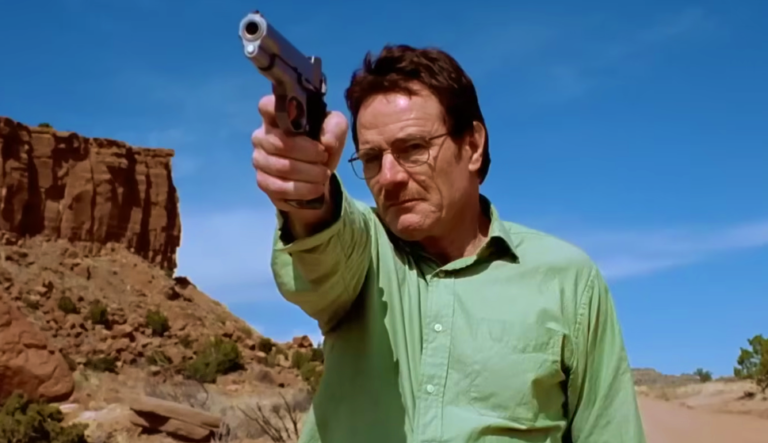 Walter com arma na mão apontando no deserto.