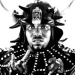 Afrika Bambaataa em imagem de arquivo como DJ, símbolo do hip-hop nas décadas de 1970 e 1980, durante apresentação musical.