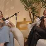 A atriz Barbie Ferreira sorrindo durante uma entrevista em estúdio de podcast.