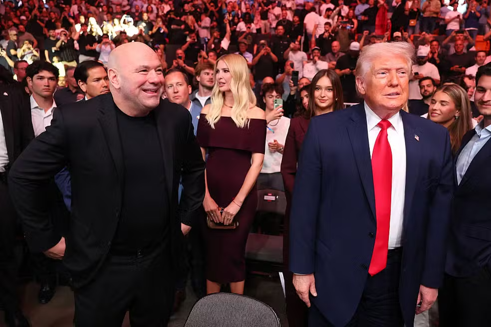 Donald Trump caminha ao lado de Dana White durante entrada em evento do UFC em Miami.