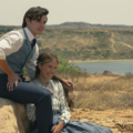 Millie Bobby Brown como Enola Holmes em cena do terceiro filme com figurino de época e ambientação europeia