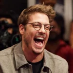 O apresentador Fábio Porchat sorrindo durante gravação de programa de televisão.