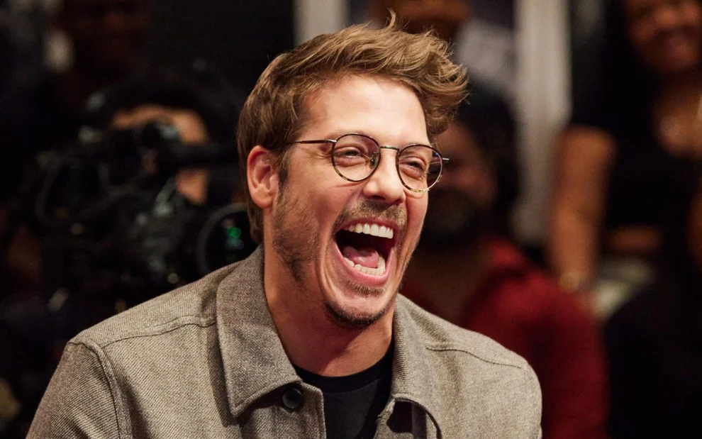 O apresentador Fábio Porchat sorrindo durante gravação de programa de televisão.