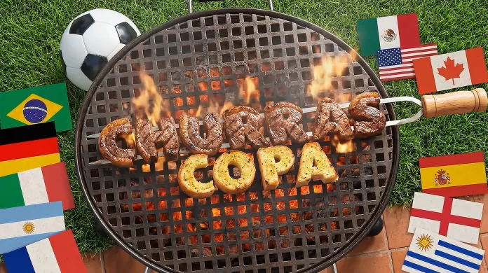 Tiago Medeiros sorri ao lado de uma churrasqueira em preparação para a Copa