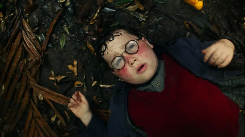 Cena do trailer de O Senhor das Moscas mostrando jovens atores em ilha após acidente de avião