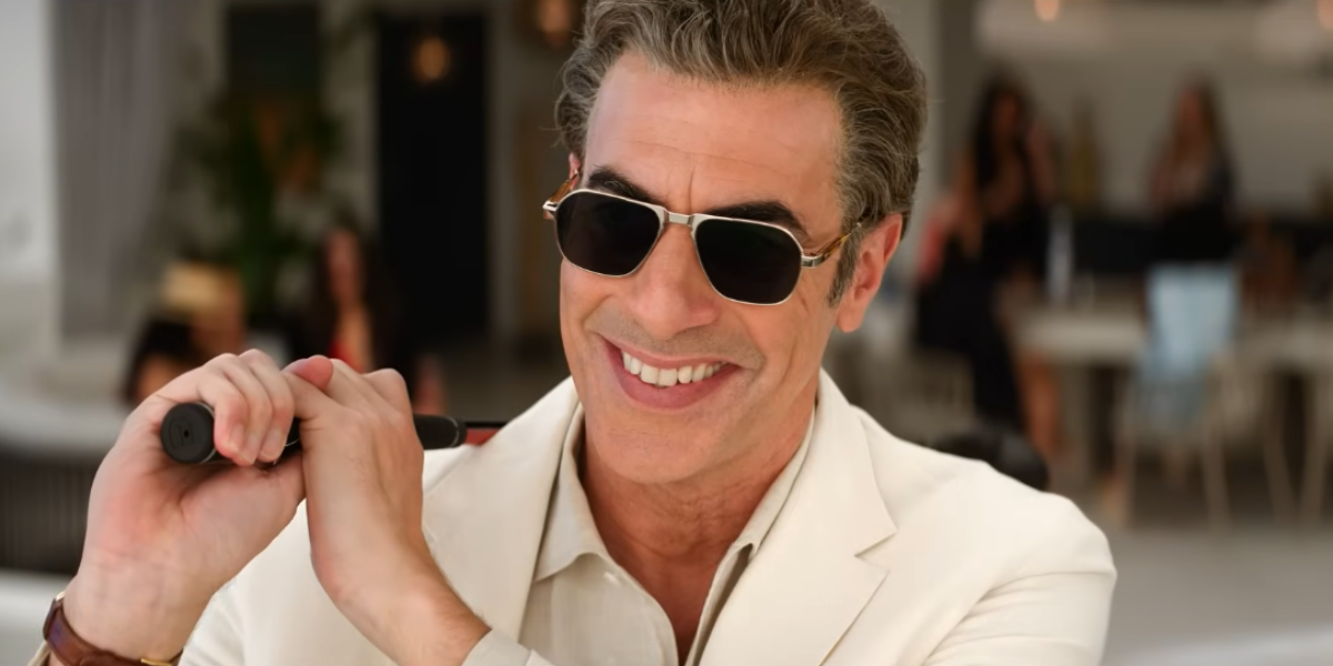 Rosamund Pike e Sacha Baron Cohen em cena da comédia Primeiro as Damas