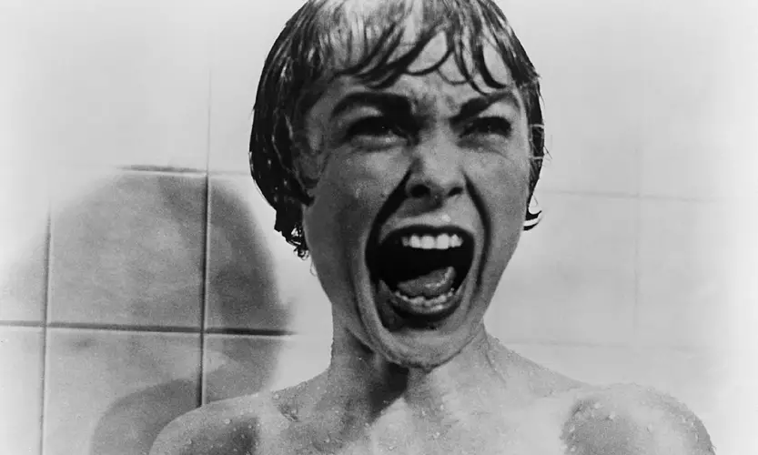 Cena clássica de Psicose, filme de Alfred Hitchcock, em motel isolado com clima de suspense psicológico.