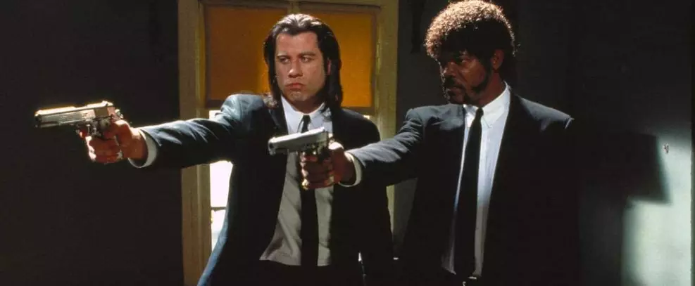Cena icônica de Pulp Fiction com os dois personagens principais apontando armas, disponível no Paramount+ Brasil