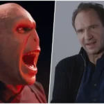 O ator Ralph Fiennes em um evento de gala sorrindo para as câmeras.