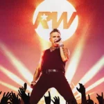 Robbie Williams em apresentação ao vivo durante show, promovendo novo álbum em turnê