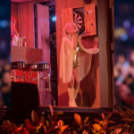 Sabrina Carpenter no palco principal do Coachella em cenário que simula Hollywood.