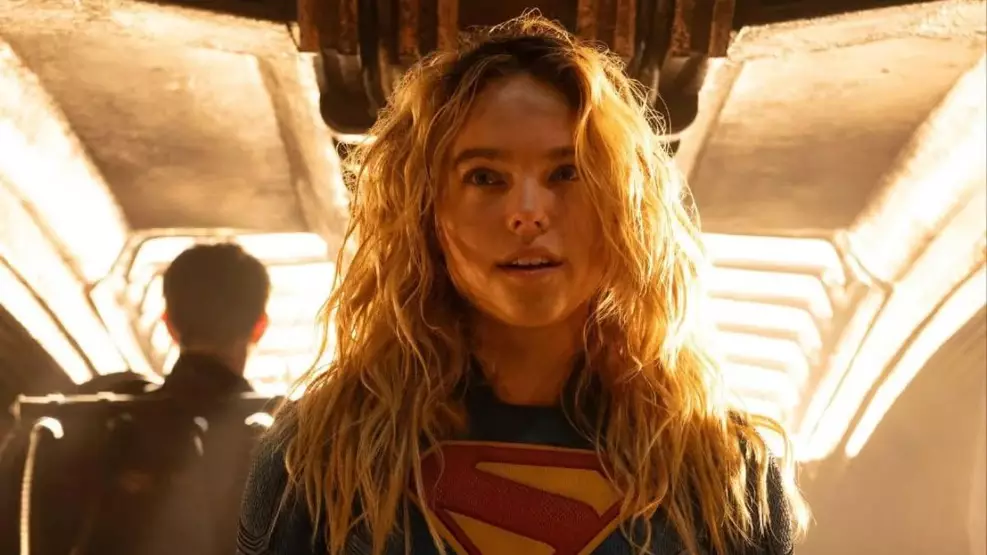 A atriz Milly Alcock caracterizada como Supergirl em um cenário espacial vasto.