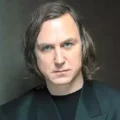 Foto de Lars Eidinger em estúdio, mostrando o ator sendo maquiado para o papel de Brainiac em Superman 2: Homem do Amanhã