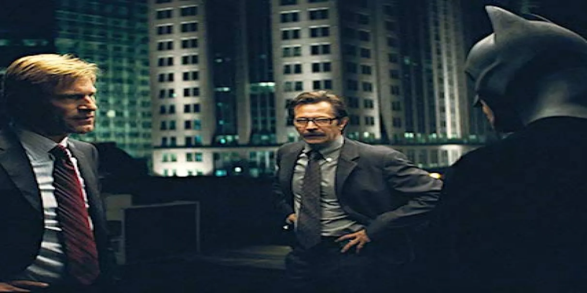 Cena do filme O Cavaleiro das Trevas com Batman em meio à atmosfera caótica de Gotham City.