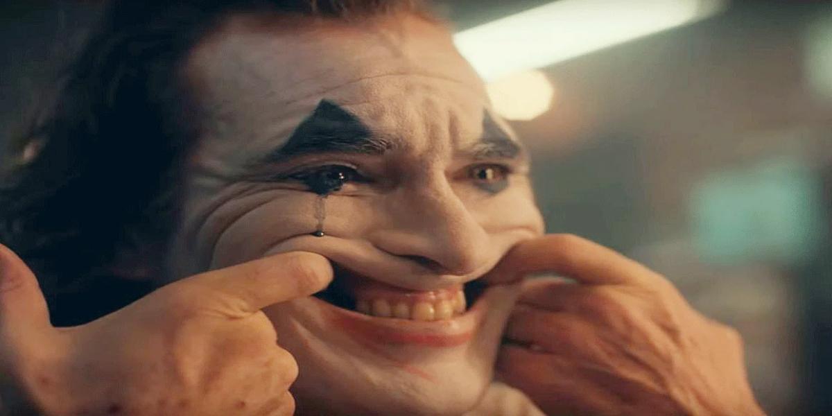 Cena de Coringa (2019) com Arthur Fleck interpretado por Joaquin Phoenix em ambiente urbano decadente.