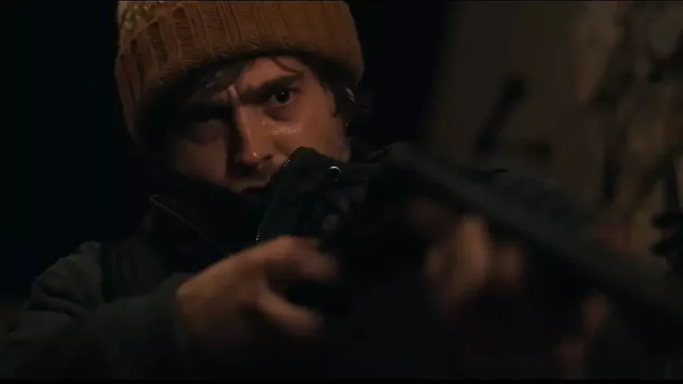 Austin Abrams em cena do reboot de Resident Evil durante ligação telefônica em Raccoon City.