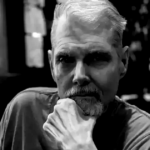 Tom Kane em registro profissional como dublador de personagens de Star Wars e As Meninas Superpoderosas.