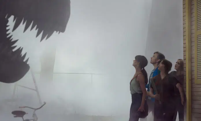 Pôster de "O Fim da Rua" com a família diante da ameaça dos dinossauros.