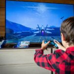 Pais e filhos jogam videogame juntos enquanto discutem a relação das famílias com os games