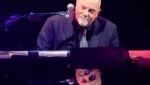 Billy Joel em apresentação ao vivo durante turnê musical.
