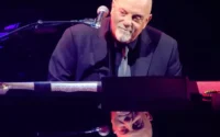 Billy Joel em apresentação ao vivo durante turnê musical.