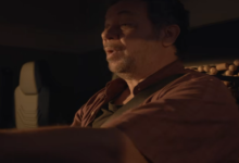 O ator Márcio Vito interpretando o homem pendurado na frente de um caminhão em cena do filme Eu Não Te Ouço.