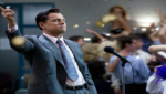 Jordan Belfort (Leonardo DiCaprio) em cena de “O Lobo de Wall Street” durante momento de ascensão em Wall Street, cercado por luxo e excesso financeiro.