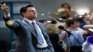 Jordan Belfort (Leonardo DiCaprio) em cena de “O Lobo de Wall Street” durante momento de ascensão em Wall Street, cercado por luxo e excesso financeiro.