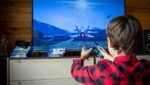 Pais e filhos jogam videogame juntos enquanto discutem a relação das famílias com os games