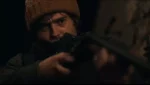 Austin Abrams em cena do reboot de Resident Evil durante ligação telefônica em Raccoon City.