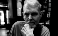 Tom Kane em registro profissional como dublador de personagens de Star Wars e As Meninas Superpoderosas.